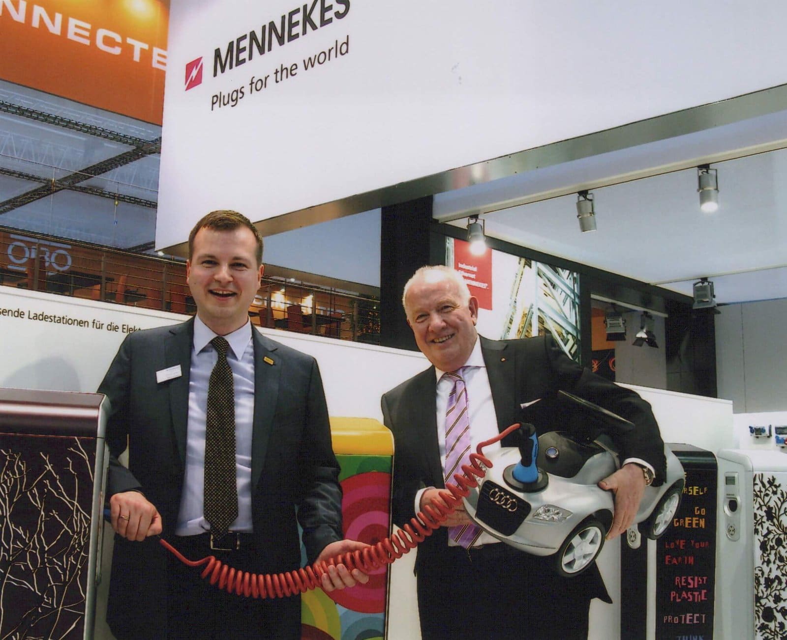 Walter und Christopher Mennekes in den 2000ern auf einer Fachmesse gemeinsam im Einsatz - mit einem Ladekabel mit MENNEKES-Stecker und Ladesäulen - Foto MENNEKES